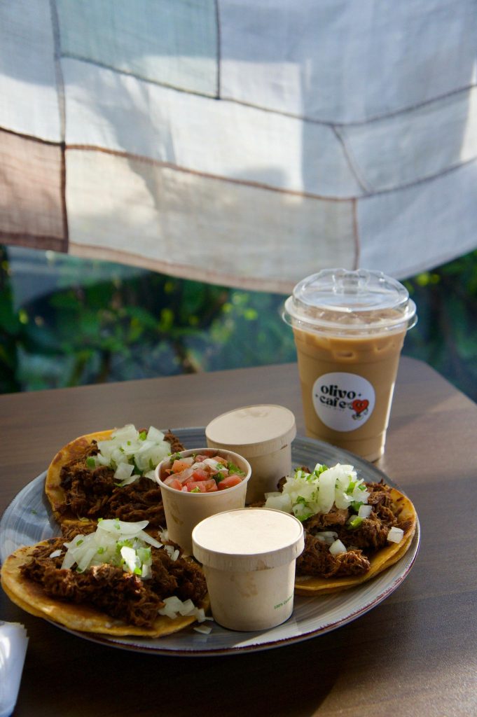 plate with three tacos, condiments and an iced coffee