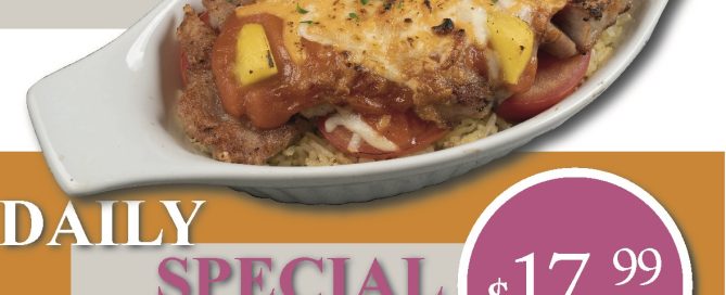 Baked pork chop on rice in oblong white dish