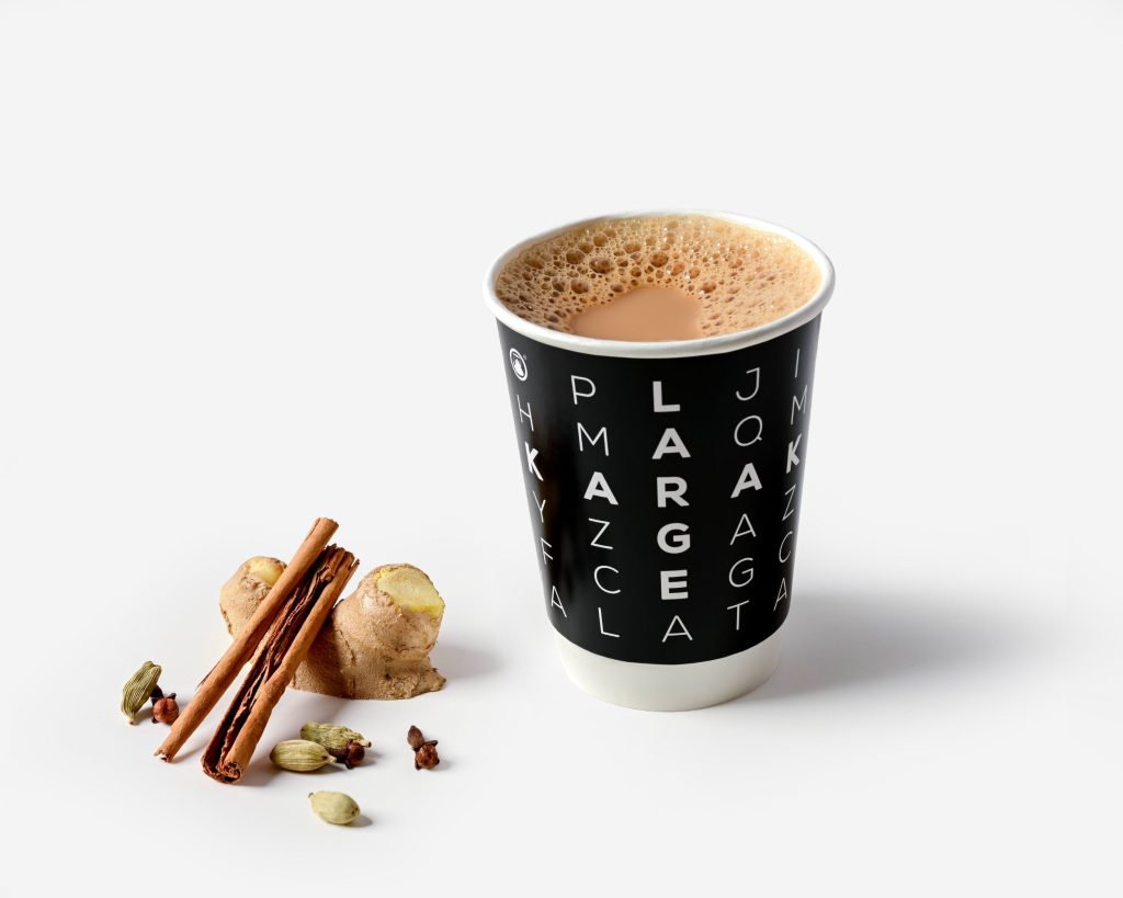 chai tea in black cup with cinnamon sticks and spices