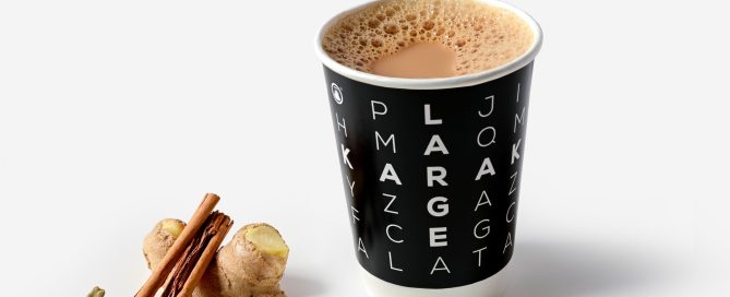 chai tea in black cup with cinnamon sticks and spices