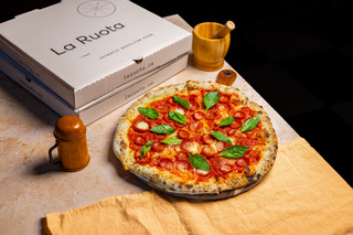 fresh pizza in front of white pizza box