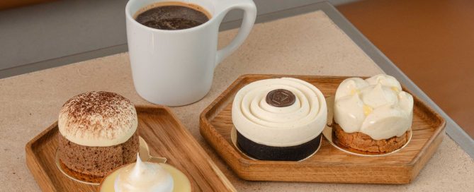 4 desserts on two trays with a cup of coffee