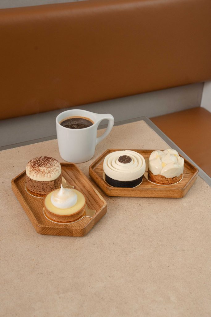 4 desserts on two trays with a cup of coffee
