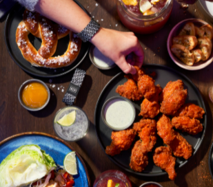 A selection of 5 dishes from The Rec Room including chicken wings, giant pretzel and dips