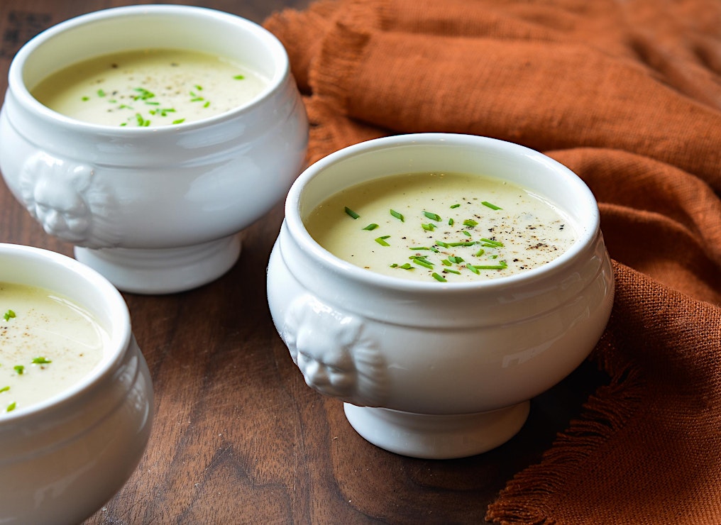 A bowl of Zulu's mini-ramen, an appetizer, and dessert, shown against blue background